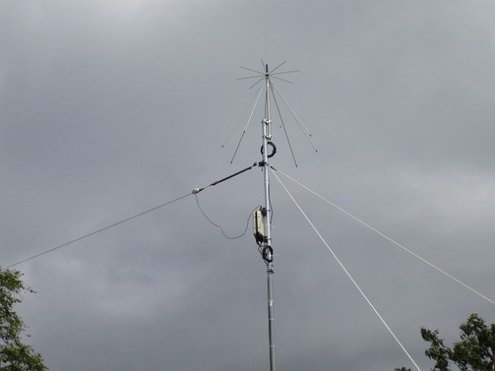 Antenn 
Min nyuppsatta antennmast. I toppen sitter en Discone och under den ser vi antennavstämningsenheten AH-4.